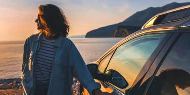 woman standing near car at sunset