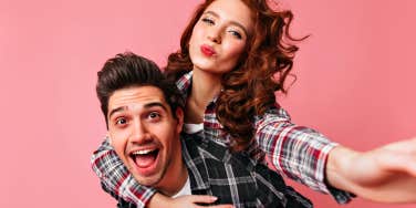 happy couple in front of a pink background