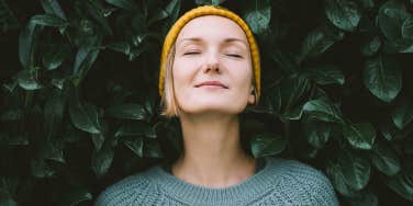 woman posing in front of greenery 