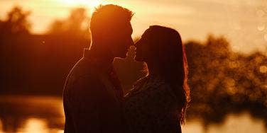 man and woman hugging at sunset 
