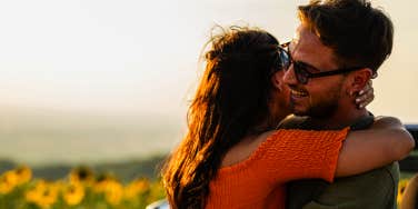 couple hugging in sunflower field