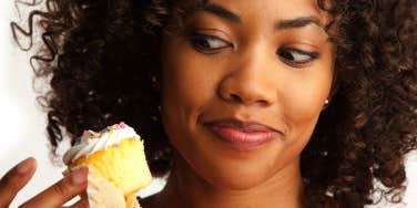 woman tempted to eat cupcake