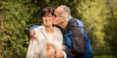 Old man kissing wife on the cheek 