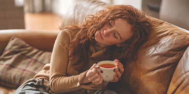 girl sitting alone on couch drinking tea