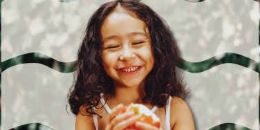 Happy young child eating an apple