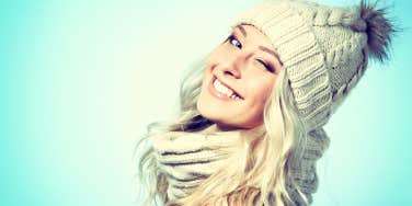 pretty blond woman wearing a beanie smiling and winking