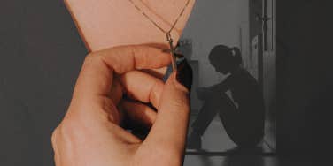 Woman holding onto cross necklace 