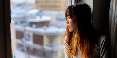 sad woman sitting near window