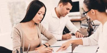 couple signing divorce papers with an attorney