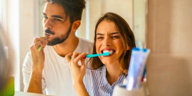 happy couple brushing their teeth