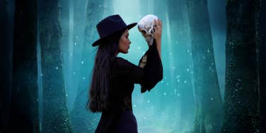 witchy woman in black holding a skull