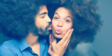 man kissing woman on the cheek