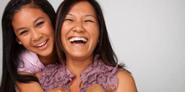 A fun loving mother and daughter share a happy moment with big smiles on their faces