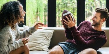 man and woman playing football indoors