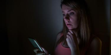 woman looking at phone in the dark