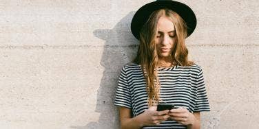 woman outside texting on cell phone