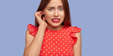 awkward woman in red shirt with purple background