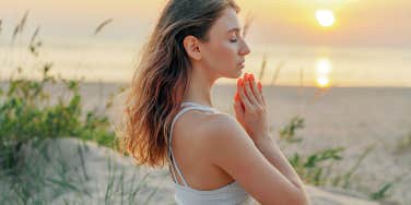 girl on beach meditating