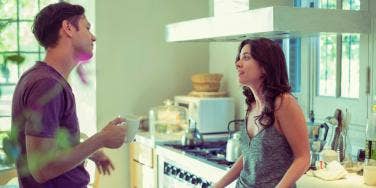 man and woman talking in the kitchen