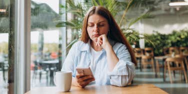 upset woman looking at phone