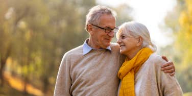 elderly couple hugging outside