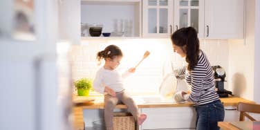 Mother with her daughter in the kitchen cooking together