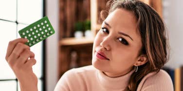 woman holding pack of birth control pills