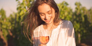 woman holds a glass of fruit alcohol in nature 