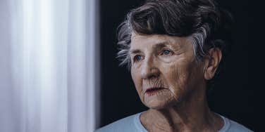 elderly woman looking out window