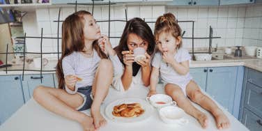 mom and her daughters hanging out in the kitchen