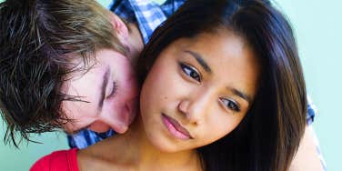 man kissing girl's neck