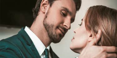 man holding woman's face about to kiss her