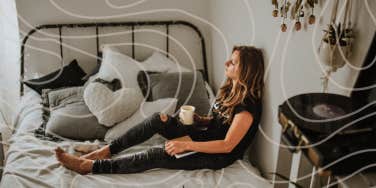 Woman sitting on bed drinking coffee 
