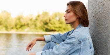 woman sitting near lake