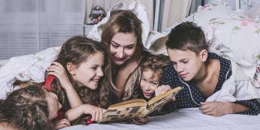 mom with multiple children reading 