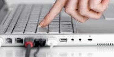 woman's hand pressing laptop keyboard