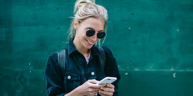 blonde woman in sunglasses texting 