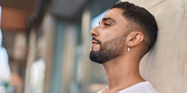 man in profile standing against wall