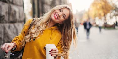 woman in yellow smiling at camera on street corner