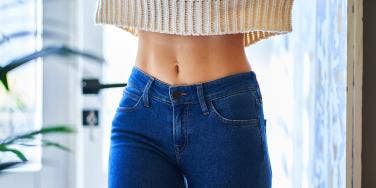photo of woman's stomach in crop top sweater