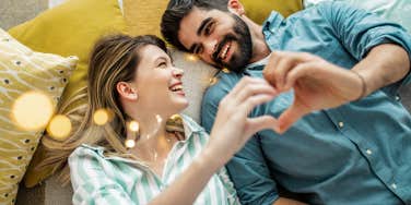 happy couple making a heart with their hands