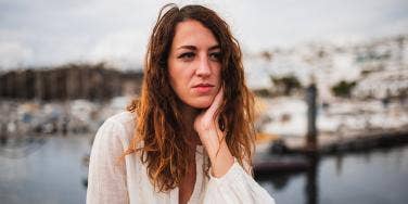 woman looking forlorn with hand on her chin