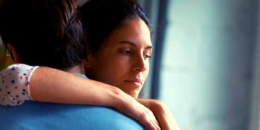 unhappy woman with her arm around her husband