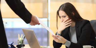 Worried businesswoman receiving a letter from a colleague in her workplace at office