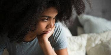 woman with hand on chin in contemplative mood