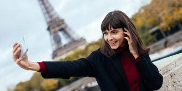 woman taking selfie with eiffel tower