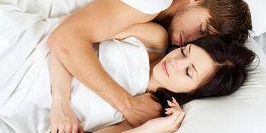 man and woman cuddling in bed