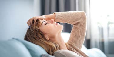 woman sitting on sofa at home thinking about important things