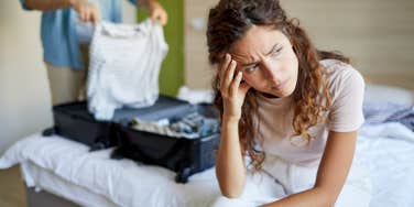 upset wife and husband packing his suitcase