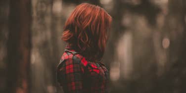 woman with red hair in the woods